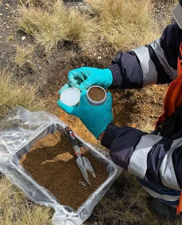 Muestra de suelo en una bolsa de muestreo junto a un frasco